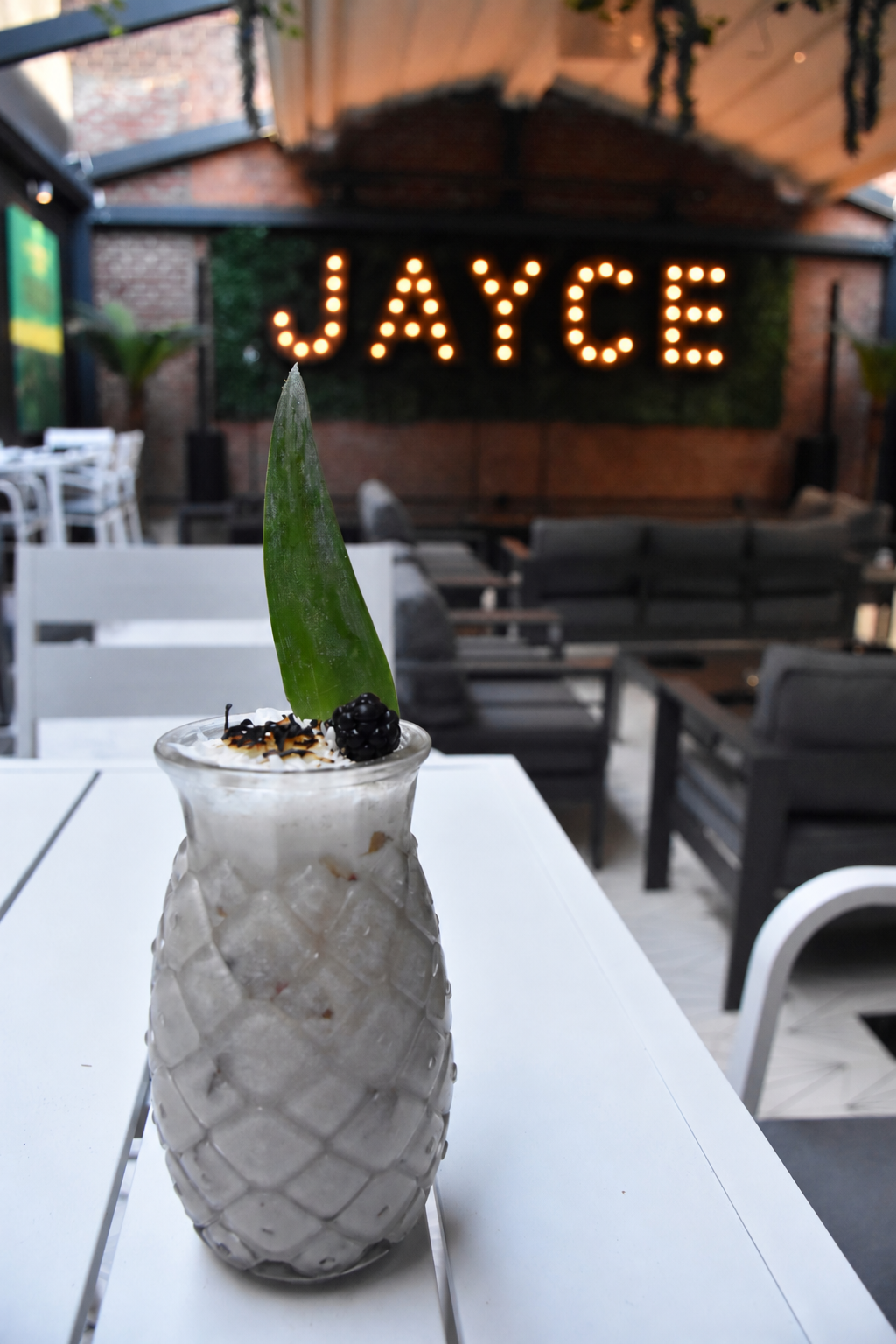 Pineapple mocktail in front of the Jayce sign